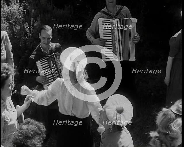 A Group of British Girls Dancing As Two British Men Play Accordion Music, 1938. Creator: British Pathe Ltd.
