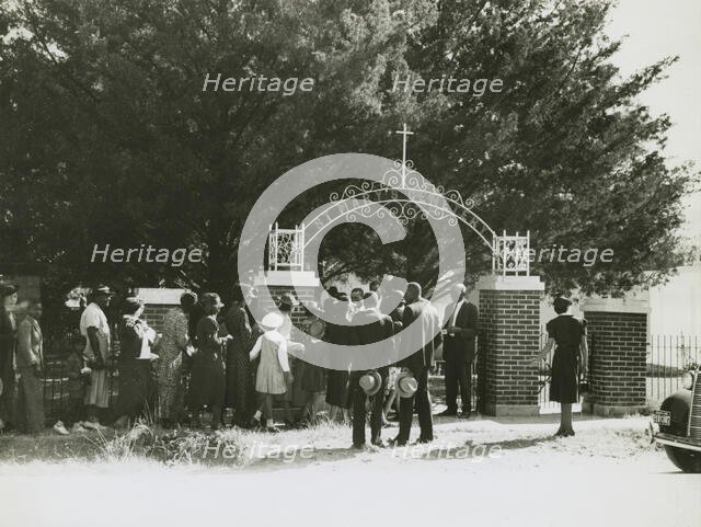 On All Saints' Day at New Roads, La. African Americans lined up at gates to enter cemetry, 1938. Creators: Farm Security Administration, Russell Lee.