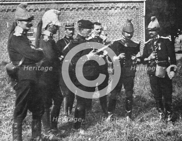 'L'aide Francaise a la Belgique; A l'ecart, l'etat-major de la brigade etudie la carte', 1914. Creator: Unknown.