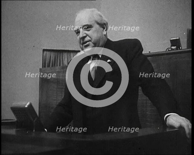 Male Representative of the League of Nations Speaking at Lectern in Front of Microphone, 1937. Creator: British Pathe Ltd.
