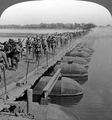 Machine gun section and infantry crossing a pontoon bridge, World War I, 1914-1918.Artist: Realistic Travels Publishers