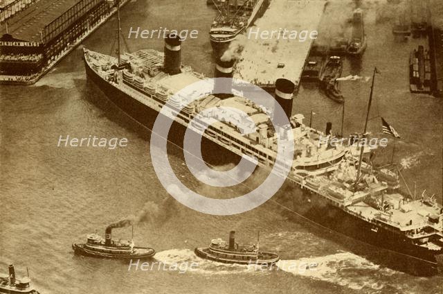 'An Aerial Photograph of the "Leviathan" Being Towed By Small Tugs Into Her Dock At New York', c1930 Creator: Unknown.