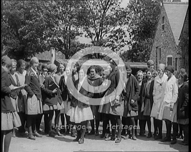 A Group of Young Female Civilians Wearing School Uniforms Standing in Front of a School, 1920. Creator: British Pathe Ltd.