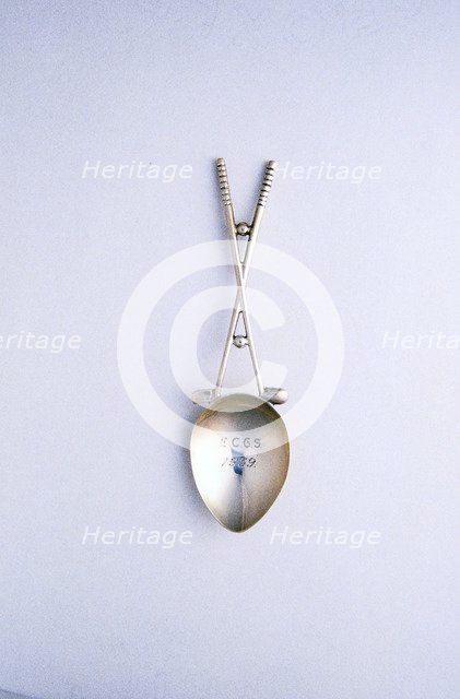 Silver spoon with crossed golf clubs motif, c1910-c1920. Artist: Unknown