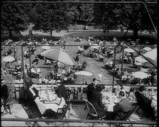 People Sitting at Tables on a Balcony While Another Group of People Sit Below, 1933. Creator: British Pathe Ltd.