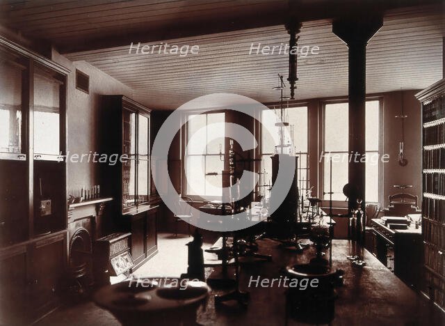 The interior of a pharmaceutical or chemical laboratory, with two long benches in the centre, glass. Creator: Unknown.