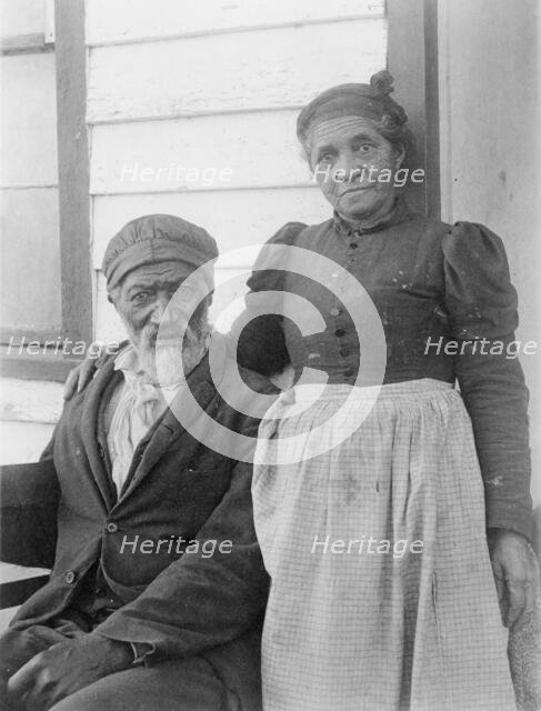 Elderly African American couple posed outside of building, near Hampton Institute..., 1899 or 1900. Creator: Frances Benjamin Johnston.