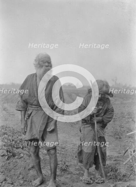 Ainu man and woman standing outside, 1908. Creator: Arnold Genthe.