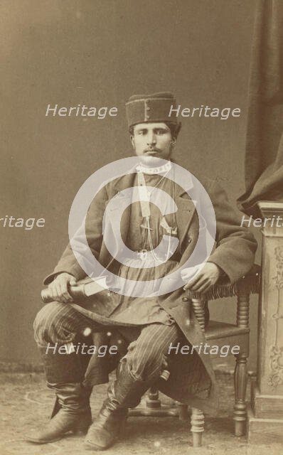 Full-length portrait of Persian man, seated, facing front, between 1870 and 1886. Creator: Unknown.