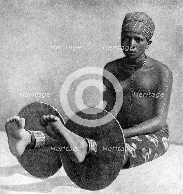 An Igbo woman wearing ankle plates, Nigeria, West Africa, 1922.Artist: Northcote Thomas