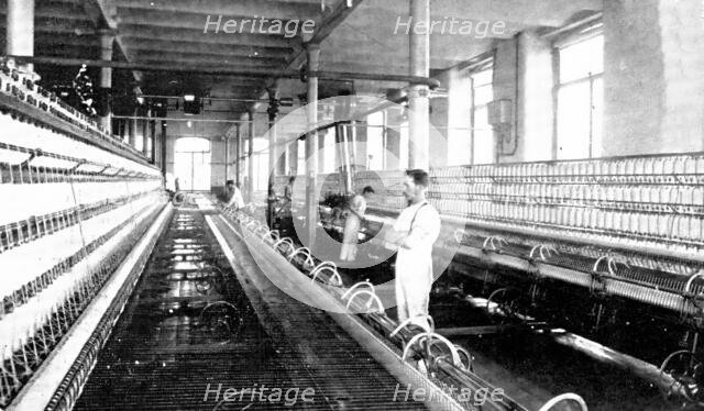 Spinning the cotton into yarn: a great spinning-mule in use, 1909. Creator: Unknown.