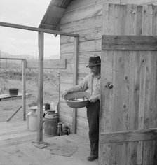 New settler shows fish he caught this morning, Priest River Valley, Bonner County, Idaho, 1939. Creator: Dorothea Lange.