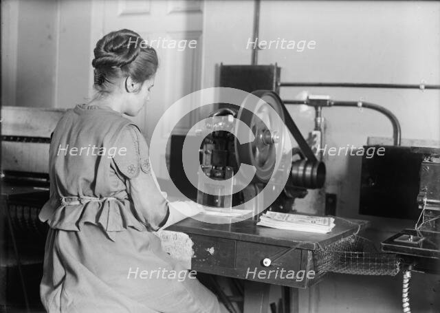Seal of The United States - Stamping Bonds, 1917. Creator: Harris & Ewing.