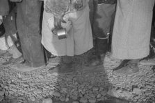 Possibly: Negroes at mealtime in the flood refugee camp, Forrest City, Arkansas, 1937. Creator: Walker Evans.