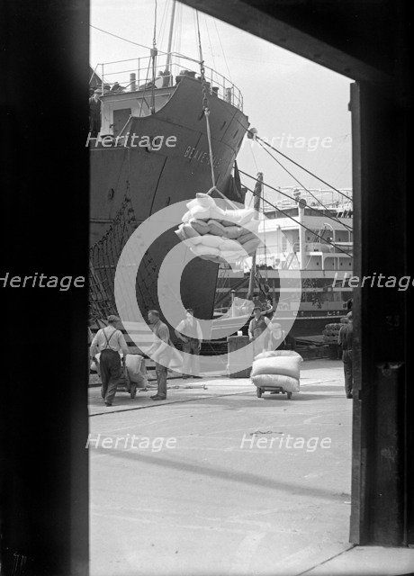 Sacks being loaded onto a ship in London docks, c1945-c1965. Artist: SW Rawlings