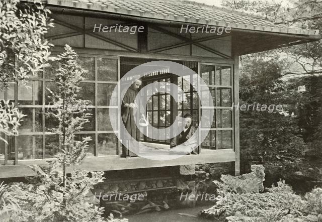 'Namikawa San Feeding His Carp', 1910. Creator: Herbert Ponting.