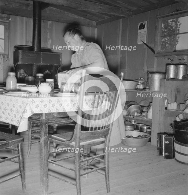 Mrs. Wardlow bakes her own bread in her dugout house, Dead Ox Flat, Malheur County, Oregon, 1939. Creator: Dorothea Lange.