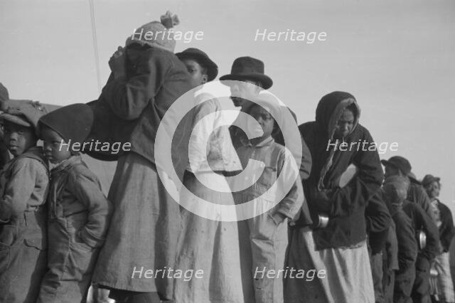 Possibly: Negroes in the lineup for food at the flood refugee camp, Forrest City, Arkansas, 1937. Creator: Walker Evans.