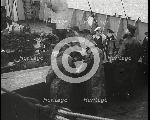 Male Ship's Crew Standing Near Rigging and Machinery on Deck of a Freighter, 1939. Creator: British Pathe Ltd.
