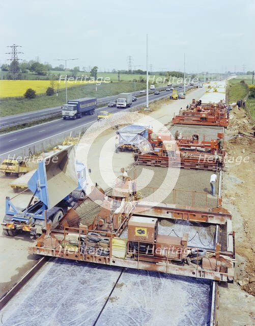 Slipform paving machines laying a road surface during widening works on the M1, 18/05/1982. Creator: John Laing plc.