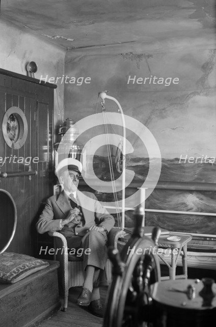 A man in a sailor's cap and eyepatch sits in a reconstructed ship's cabin, c1945-c1965. Artist: SW Rawlings