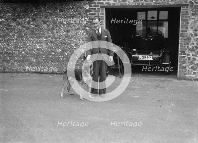 Geoffrey Baker standing in front of a Minerva 5954 cc car. Artist: Bill Brunell.