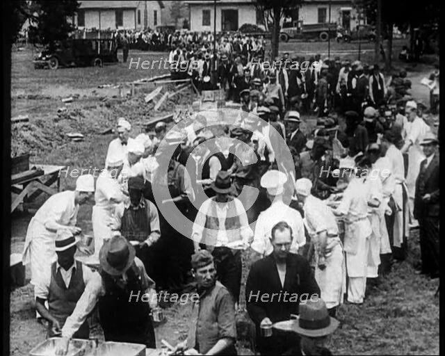 American Civilians Serving Meals for a Large Crowd on a Queue Outdoors, 1930. Creator: British Pathe Ltd.