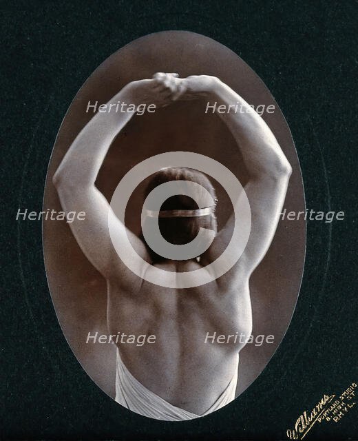 A young woman posing semi-naked, back view, with her arms in the air, in a photographic..., c1903. Creator: Unknown.