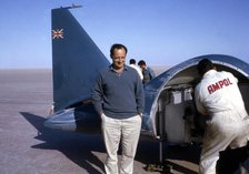 Donald Campbell  in front of Bluebird CN7, Lake Eyre, Australia, 1964. Creator: Unknown.
