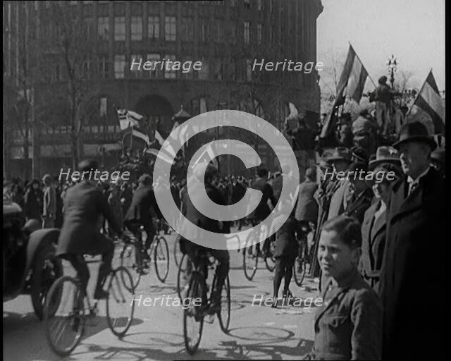 Male Civilians Driven in Trucks Parade Waving Flags. Other Male Civilians Ride Alongside on..., 1924 Creator: British Pathe Ltd.