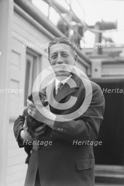 Von Lueckner, Felix, Count, with dog, standing outdoors, 1931 June 5. Creator: Arnold Genthe.