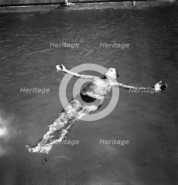 A man takes a refreshing dip in a swimming pool during the hot summer, Sweden, 1943. Artist: Karl Sandels