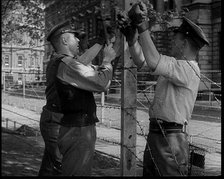 Three Men Setting up a Barbed Wire Fence, 1940. Creator: British Pathe Ltd.