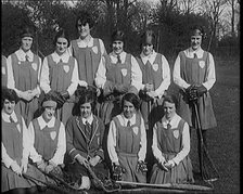 A Group of Young Female Civilians Wearing Gymslips Holding Lacrosse Sticks, 1920. Creator: British Pathe Ltd.