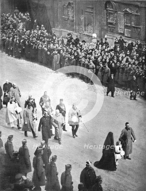 'Derriere le cercueil de Francois-Joseph; le nouveau couple imperial, suivi de souverains..., 1916. Creator: Unknown.