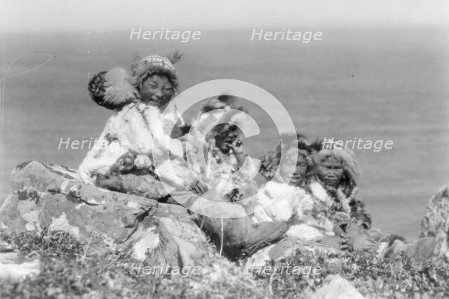 Four Eskimo children, at edge of cliff, in holiday costume, Nunivak, Alaska, c1929. Creator: Edward Sheriff Curtis.
