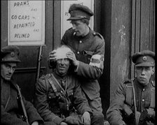 Irish Soldiers Sitting in the Street and Tending to Their Injuries from Fighting in Dublin, 1922. Creator: British Pathe Ltd.