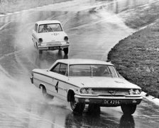Ford Galaxie, J.Sears, leads Ford Anglia in wet at Brands Hatch 1963. Creator: Unknown.