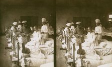 Nurses and a doctor attending wounded soldiers on a hospital ward, c1905. Creator: Underwood & Underwood.