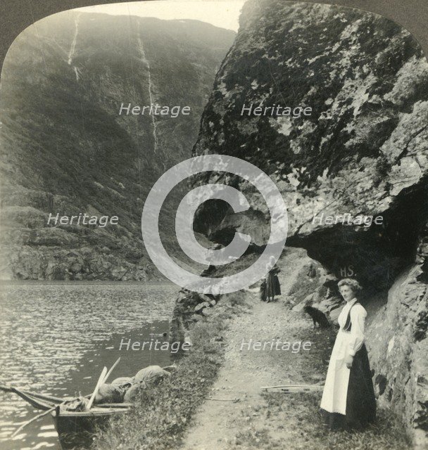 'Where the road creeps under the jutting cliffs by the waters of the Nerofjord, Norway', c1905. Creator: Unknown.