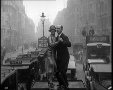 A Couple Dancing the Charleston on the Top of a Car Driving Down a London Street, 1926. Creator: British Pathe Ltd.