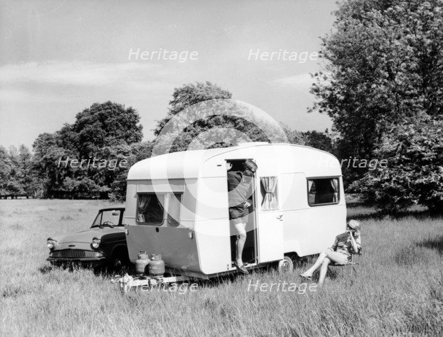 Couple on holiday with their 1963 Sprite Alpine caravan, (c1963?). Artist: Unknown