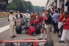 Graham Hill watches Mechanics working on a car, French Grand Prix, Rouen, 1968. Artist: Unknown