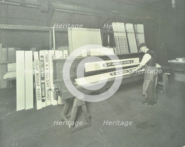 Man stencilling signs for tram cars at Charlton Central Repair Depot, London, 1932. Artist: Unknown.