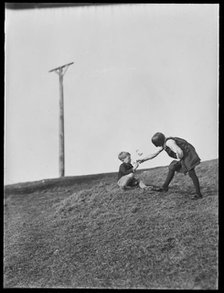Two children playing in front of Combe Gibbet, Inkpen Hill, Inkpen, West Berkshire, 1925-1935. Creator: George R Long.