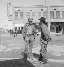 Idle pea pickers discuss prospects for work, Calipatria, Imperial Valley, California, 1939. Creator: Dorothea Lange.