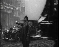 A Male Police Officer Directing the Traffic in the Snow, Facing the Camera, 1920s. Creator: British Pathe Ltd.