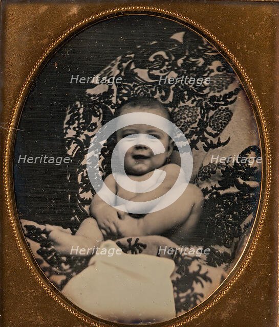 [Smiling, Nude Baby Holding Foot, Seated on Furniture Draped with Floral Print Fabric], 1850s. Creator: Unknown.