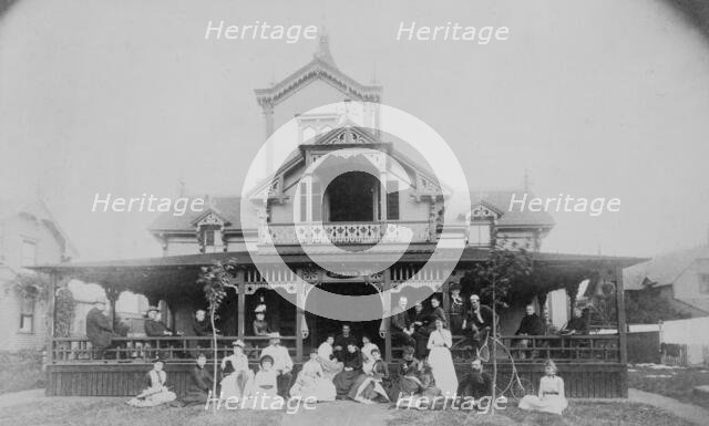 Frances Benjamin Johnston and family on porch and in front of house, between 1890 and 1910. Creator: Unknown.