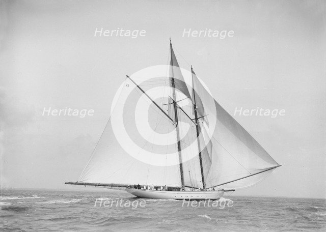 The 250 ton schooner 'Germania' sailing downwind with spinnaker, 1912. Creator: Kirk & Sons of Cowes.